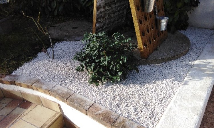 sol recouvert de graviers blanc plantation arbuste de saison petit chapiteaux repose pot de fleurs